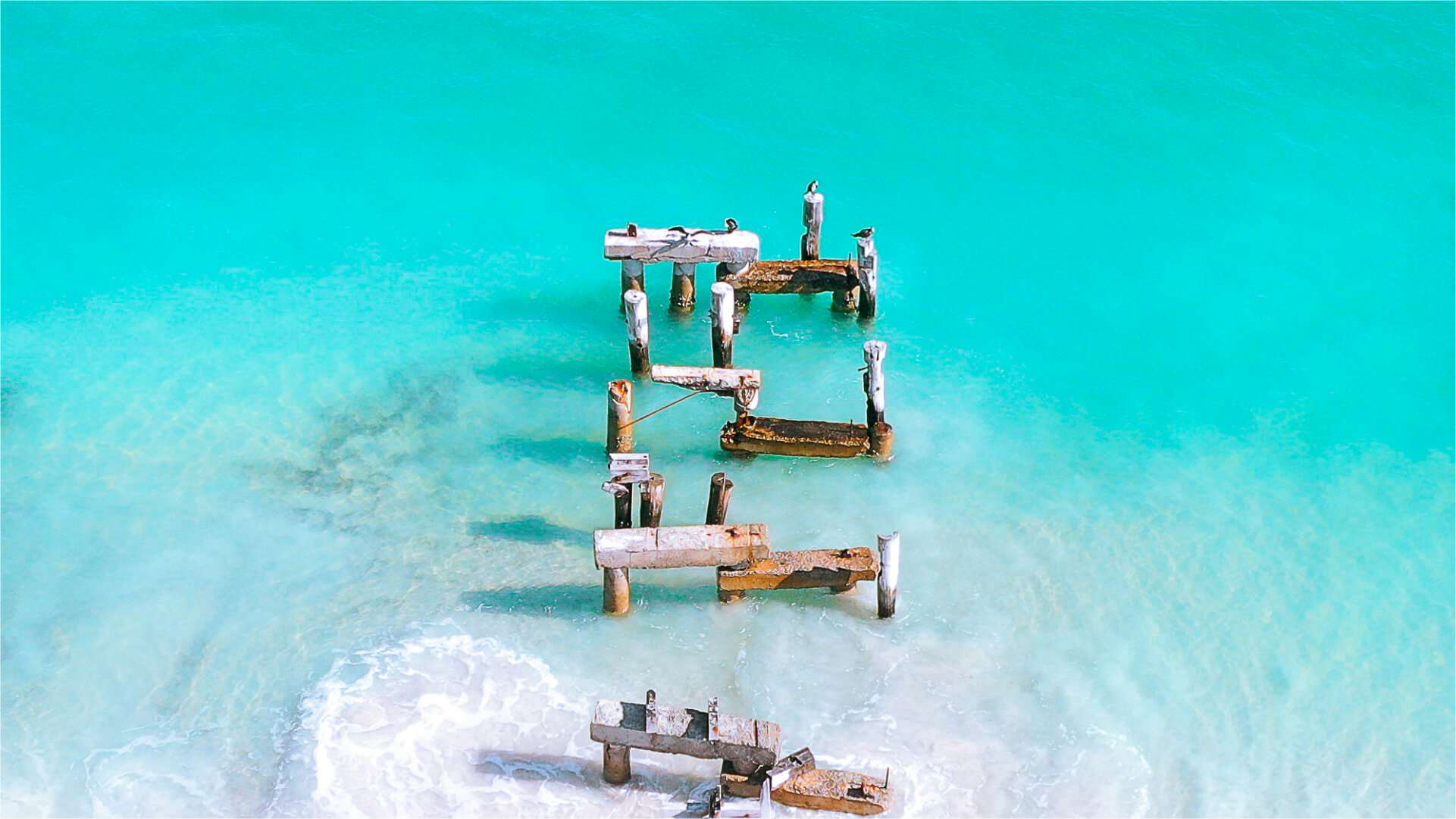 Remains of an old jetty in turquoise waters.